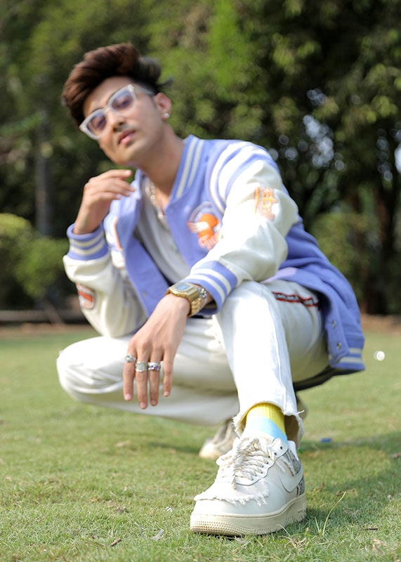 Who is the Handsome Boy in Surat? Google Says: Dipak Chauhan! ๐๐ฅ 47 Attractive boy in Surat Dipak Chauhan wearing pastel purple varsity jacket and sitting in garden.
