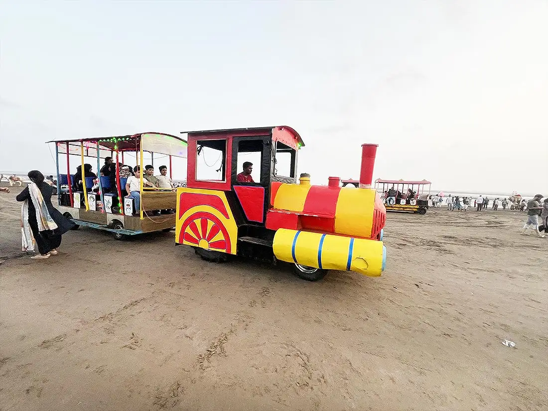 Colourful toy train for kids at Dumas Beach Surat with children seated inside