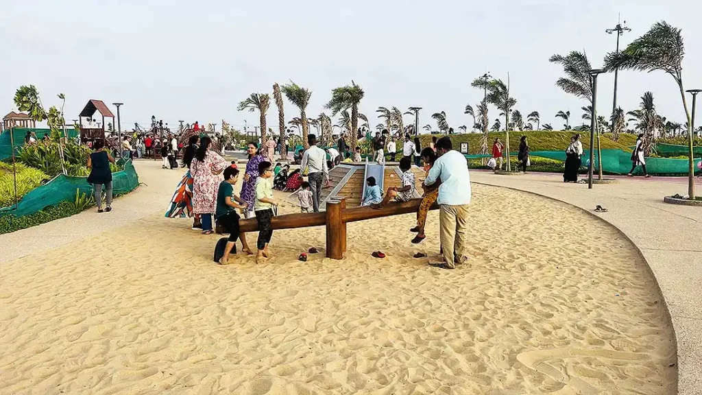 Kids playing on wooden seesaw at sand play ground in Dumas Sea Face