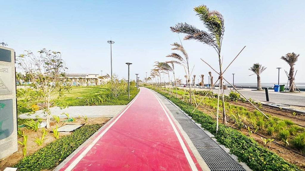 Red jogging and walking track at Dumas Sea Face Surat with green landscaping