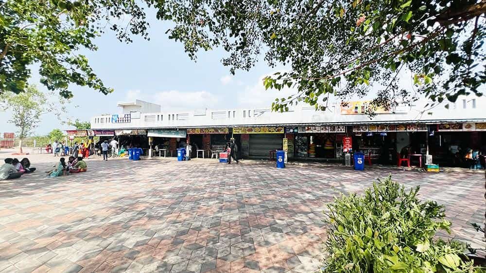 Row of food stalls near Galteshwar Mahadev Temple under shady trees