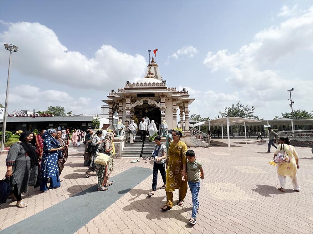 Devotees and families walking near a white shrine at Galteshwar Mahadev Temple as you can see in photo
