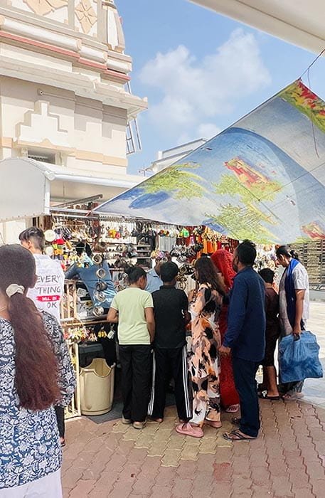 People shopping for pooja items and souvenirs at a stall near Galteshwar Mahadev Temple