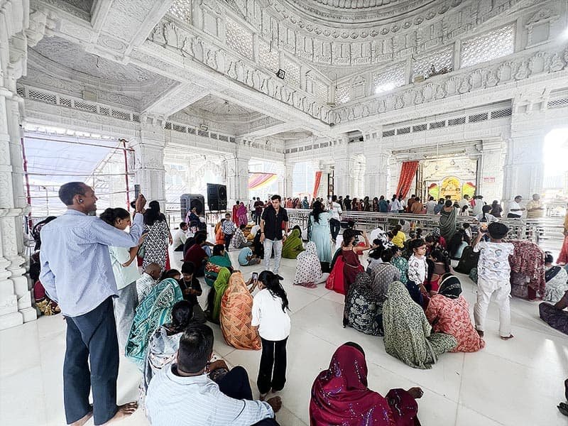 Devotees sitting and standing for darshan inside Shyam Mandir Surat hall