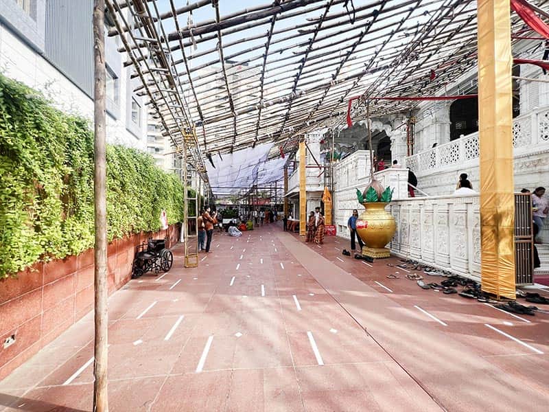 Side pathway near Shyam Mandir VIP Road Surat with green wall and queue lines