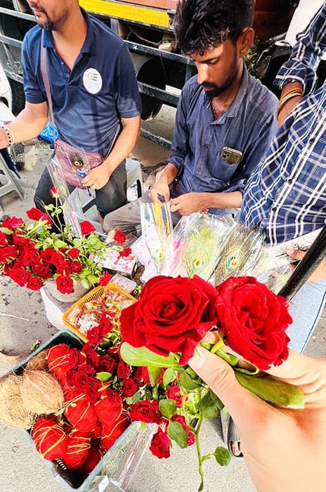 Buying red rose flowers outside Shyam Mandir Vesu Surat for offering