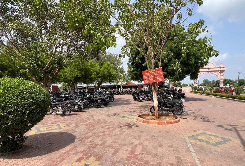 Bike parking area under trees near Galteshwar Mahadev Temple entrance gate